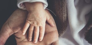 Jak zadbać o przyszłość dziecka? dziecięca dłoń na dorosłej dłoni